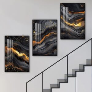 Black and gold marble wall art set beside a modern staircase