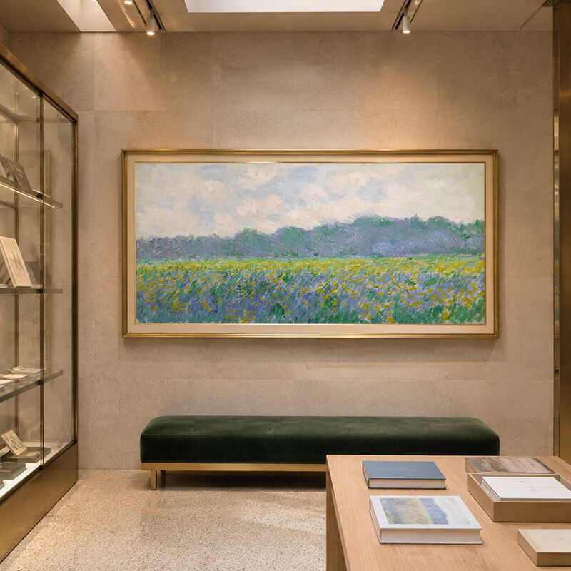 Monet Yellow Irises wall art displayed in a museum-inspired cultural space with a green velvet bench.