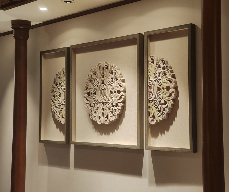 Oversized floral medallion carved wood wall art in a hotel interior