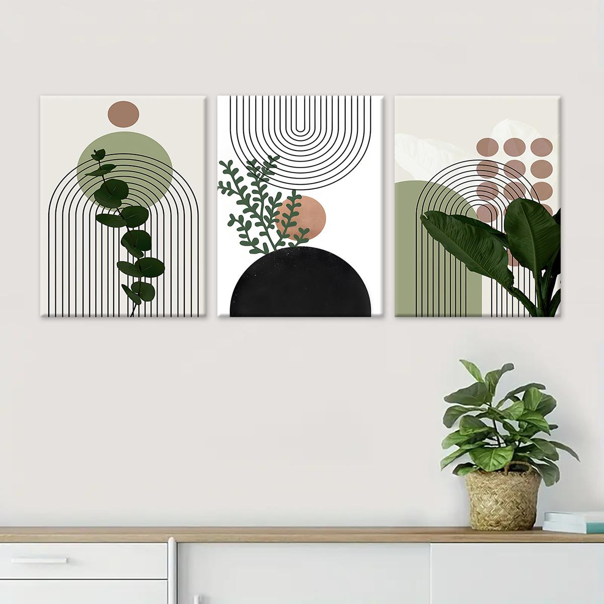 Three piece sage green botanical canvas wall art in a minimalist room
