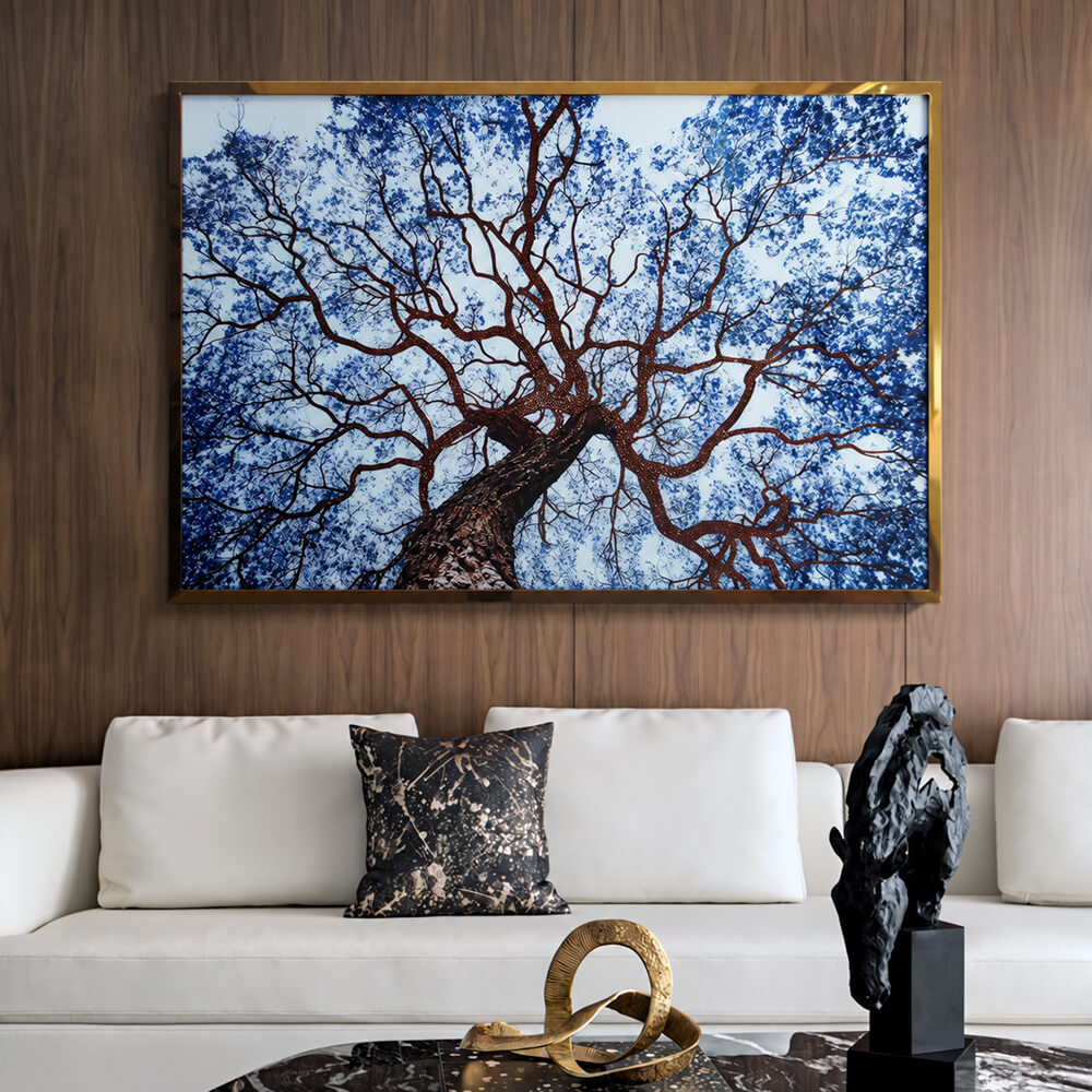 Framed blue tree wall art above a white sofa against wood paneling