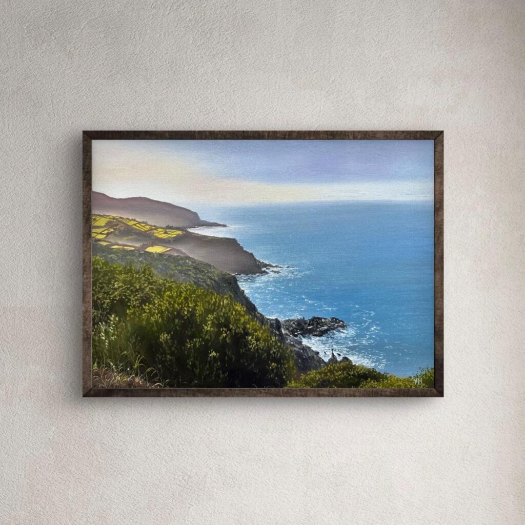 Framed coastal landscape oil painting on a neutral wall