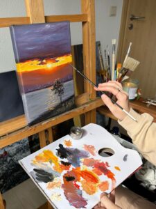 Artist painting a sunset landscape oil painting on canvas