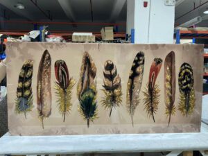Boho feather wall art featuring shimmering gold accents