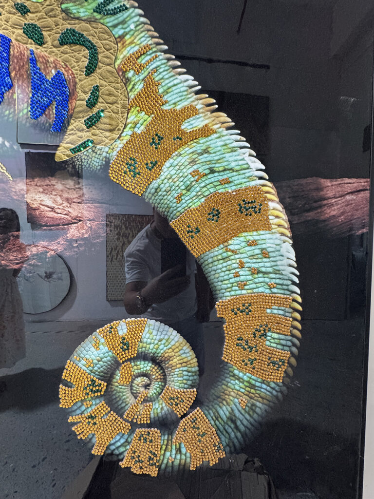 Curled tail detail with amber beads on jeweled chameleon artwork