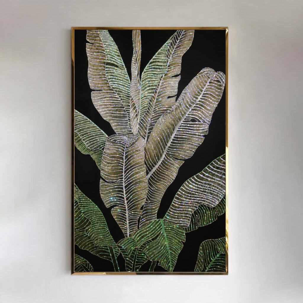 Front view of green and gold tropical leaves with crystal accents and a gold frame